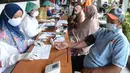 Petugas kesehatan memeriksa kesehatan warga Kelurahan Gedong untuk penyuntikkan vaksin COVID-19 di Jakarta, Rabu (23/6/2021). Vaksin bisa mengurangi tingkat keparahan infeksi dan kematian akibat virus, termasuk yang disebabkan varian Delta. (merdeka.com/Imam Buhori)