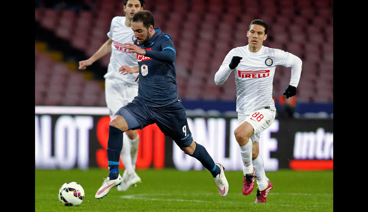Penyerang Napoli, Gonzalo Higuain berusaha membawa bola melewati dua pemain Inter Milan pada laga serie A di stadion San Paolo, Italy (8/3/2015).  Napoli bermain imbang 2-2 dengan Inter Milan. (Reuters/Ciro De Luca)