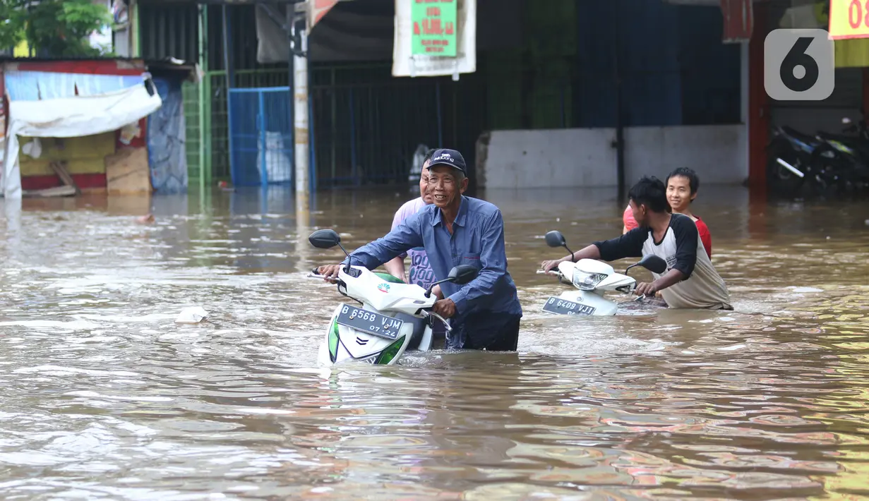 Warga membawa motor melintasi banjir yang merendam jalan Raya KH Hasyim Ashari, Ciledug ,Tangerang, Rabu (1/1/2020). Banjir setinggi dada orang dewasa membuat jalur penghubung Tangerang ke Jakarta tersebut terputus tidak dapat dilintasi. (Liputan6.com/Angga Yuniar)