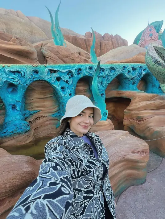 Pada momen lain, Enzy memadukan kemeja bermotifnya dengan bucket hat warna putih dan  long pants hitam. [@enzystoria]