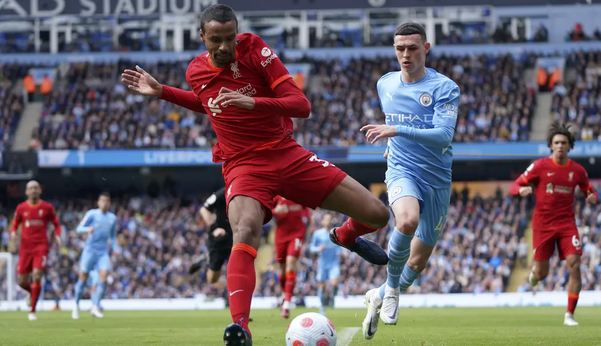 Pemain Liverpool Joel Matip (kiri) berduel memperebutkan bola dengan pemain Manchester City Phil Foden pada pertandingan sepak bola Liga Inggris di Etihad Stadium, Manchester, Inggris, 10 April 2022. Laga berakhir imbang 2-2. (AP Photo/Jon Super)