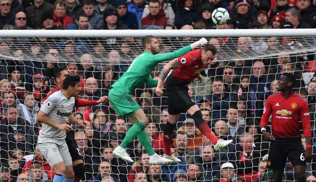 Kiper Man United, David de Gea melakukan penyelamatan pada laga lanjutan Premier League yang berlangsung di Stadion Old Trafford, Minggu (14/4). Man United menang 2-1 atas West Ham. (AFP/Paul Ellis)