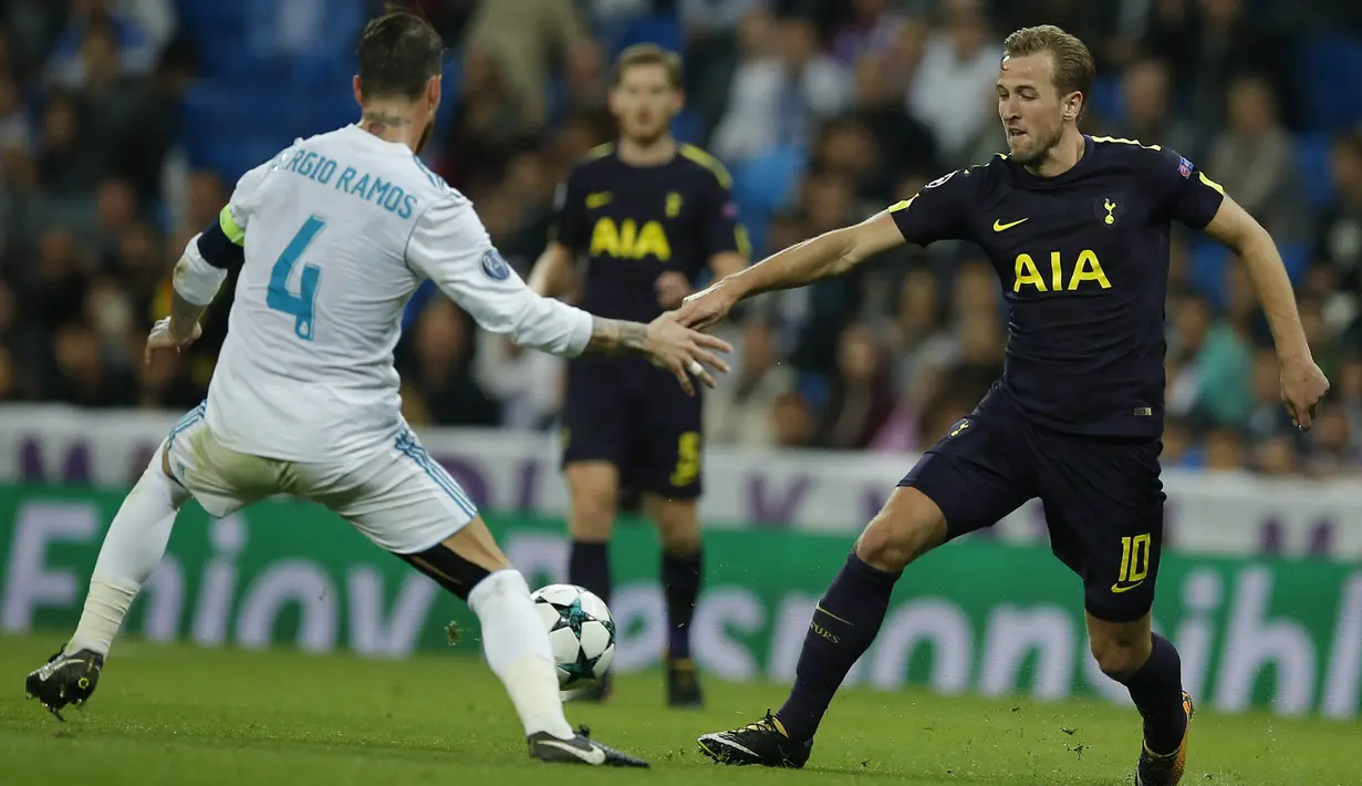 Striker Tottenham, Harry Kane, berusaha melewati bek Real Madrid, Sergio Ramos, pada laga Liga Champions di Stadion Santiago Bernabeu, Madrid, Selasa (17/10/2017). Kedua klub bermain imbang 1-1. (AP/Paul White)