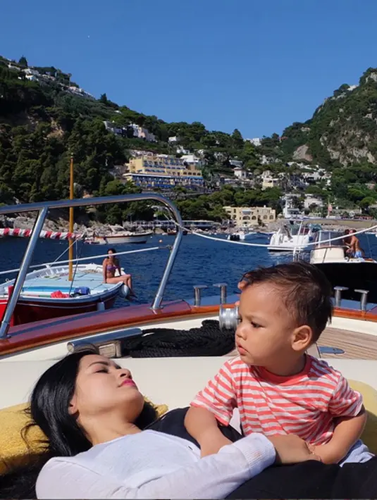 Titi Kamal dan baby Juna bersantai di atas kapal, Pulau Capri, Itali. (Photo : Instagram)