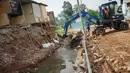 Alat berat mengeruk beton turap saluran air yang longsor di kawasan Jagakarsa, Jakarta, Kamis (17/9/2020). Selain karena hujan lebat, longsor diduga karena erosi tanah akibat pembuangan saluran air pencuci piring dan toilet dari warung makan di sekitar bantaran. (Liputan6.com/Immanuel Antonius)