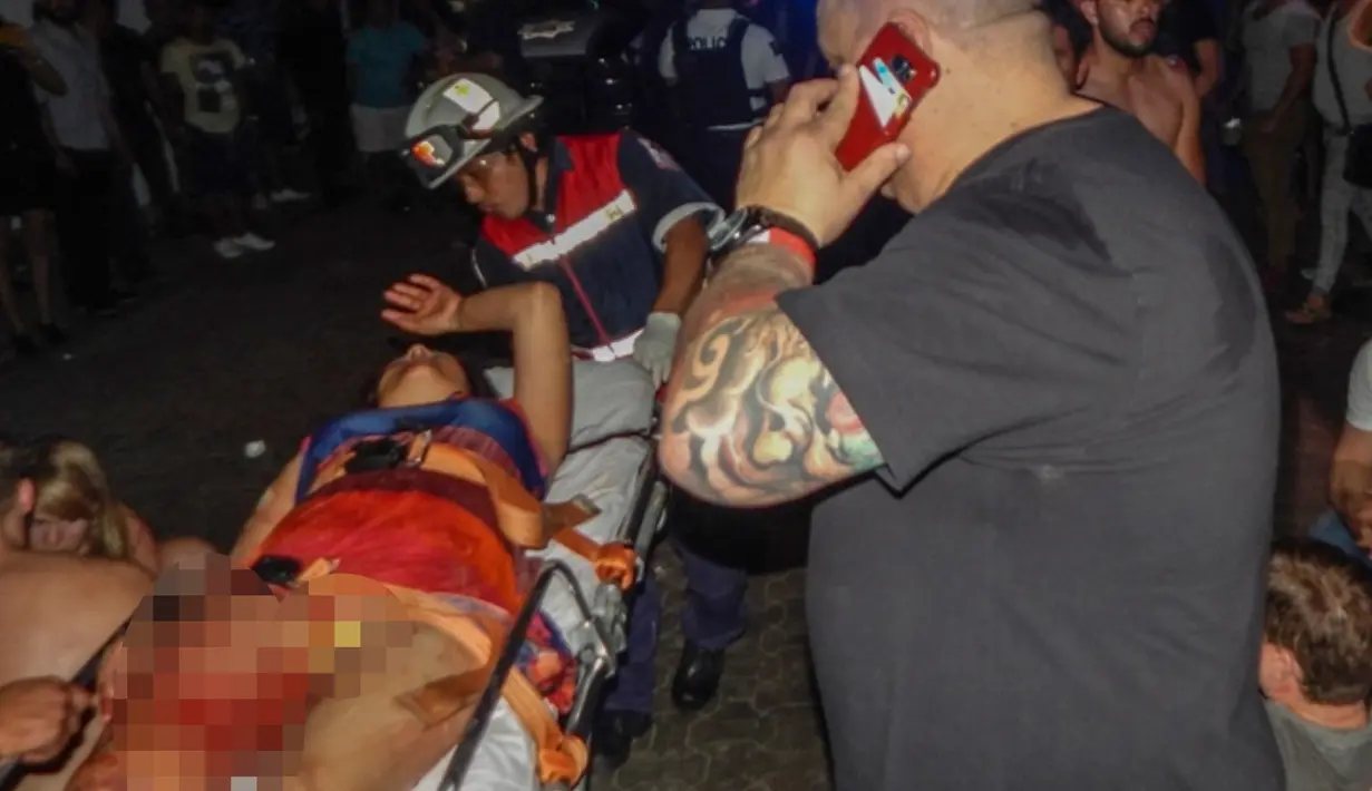 Seorang wanita terluka akibat penambakan di kelab malam Blue Parrot dievakuasi oleh tim medis, Meksiko (16/1). Menurut pemerintah setempat, korban adalah satu orang warga AS, warga Italia, warga Kolombia dan dua orang warga Kanada. (AFP/Victor Vargas)