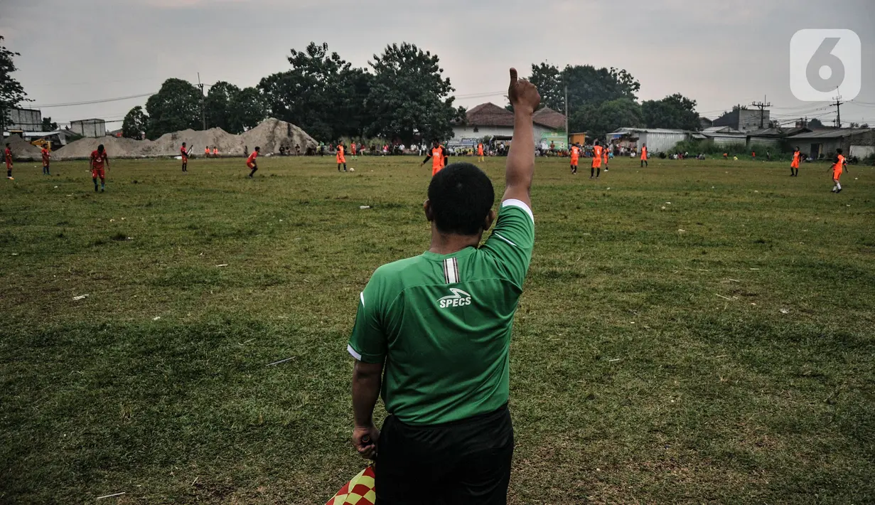 Wasit memberikan kode saat dimulainya pertandingan 'Liga Kocok' di Desa Ragajaya, Bojong Gede, Kabupaten Bogor, Jawa Barat, Minggu (17/10/2021). Segala kalangan dapat menyaksikan pertandingan ini secara gratis dengan jajanan kaki lima yang menghiasi di sisi lapangan. (merdeka.com/Iqbal S. Nugroho)