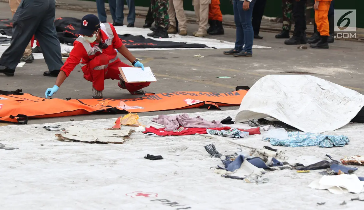 Petugas mengidentifikasi kantung jenazah korban jatuhnya pesawat Lion Air PK LQP di Pelabuhan JICT 2, Jakarta, Senin (5/11). Hingga hari kedelapan jatuhnya pesawat Lion Air PK-LQP, tim SAR gabungan terus mencari korban. (Liputan6.com/Helmi Fithriansyah)