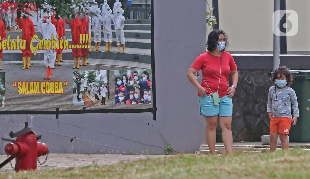 Pasien berstatus OTG (Orang Tanpa Gejala) bersama anaknya berjemur di RSDC Wisma Atlet, Jakarta, Selasa (26/1/2021). Data Satgas Covid-19 per Selasa (26/1) mencatat kasus COVID-19 di Indonesia bertambah 13.094 sehingga total menyentuh satu juta, tepatnya 1.012.350. (Liputan6.com/Herman Zakharia)