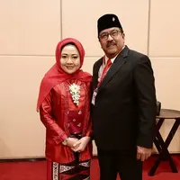 Dampingi suami bertugas, Dewi tampil anggun kenakan kebaya kutubaru merah sederhana yang dipadukan dengan angkin dan hijab warna senada. [@dewiranokarno].
