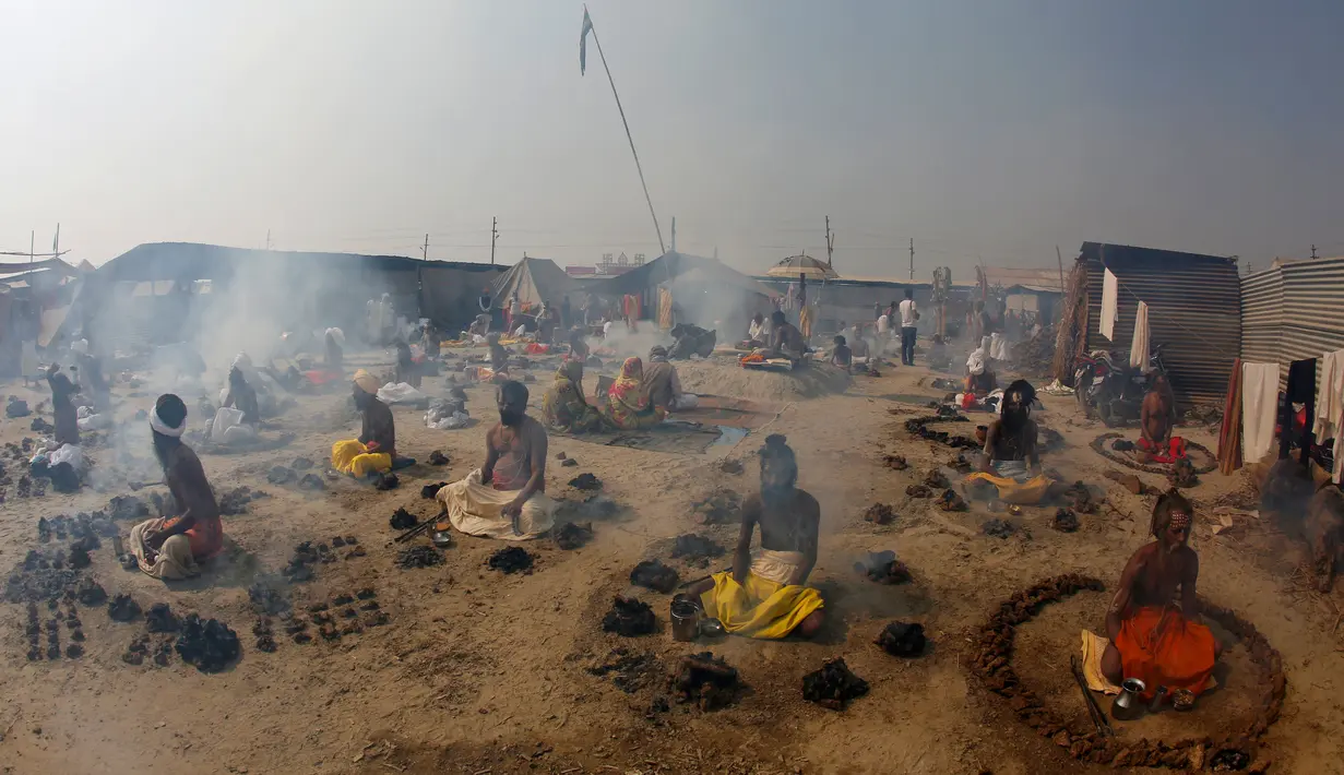 Orang suci Hindu membakar kotoran sapi kering dalam ritual Basant Panchami dalam festival tahunan Magh Mela di Allahabad, India, Senin (22/1). Basant Panchami dilakukan di kawasan Sangam, pertemuan Sungai Gangga dan Yamuna. (AP Photo/Rajesh Kumar Singh)