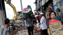 Warga saat mengevakuasi barang-barang milik mereka saat penggusuran pemukiman di pinggir Waduk Pluit, Penjaringan, Jakarta, Minggu (11/1/2015). (Liputan6.com/Faizal Fanani)