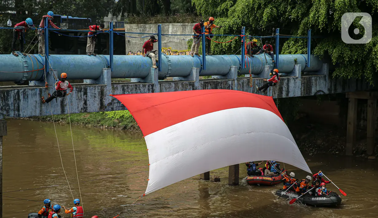 Sejumlah relawan membentangkan bendera Merah Putih di aliran kali
Ciliwung di kawasan Sudirman, Jakarta, Minggu (22/8/2021). Pembentangan atau pengibaran bendera Merah Putih tersebut dilaksanakan untuk memperingati HUT ke-76 RI. (Liputan6.com/Faizal Fanani)
