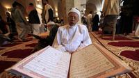 Seorang pria membaca Al-Quran selama bulan Ramadan di Masjid Agung Sanaa, Yaman, Minggu (26/4/2020). Kaligrafi dan dekorasi merupakan kekhasan Masjid Agung Sanaa. (Mohammed HUWAIS/AFP)