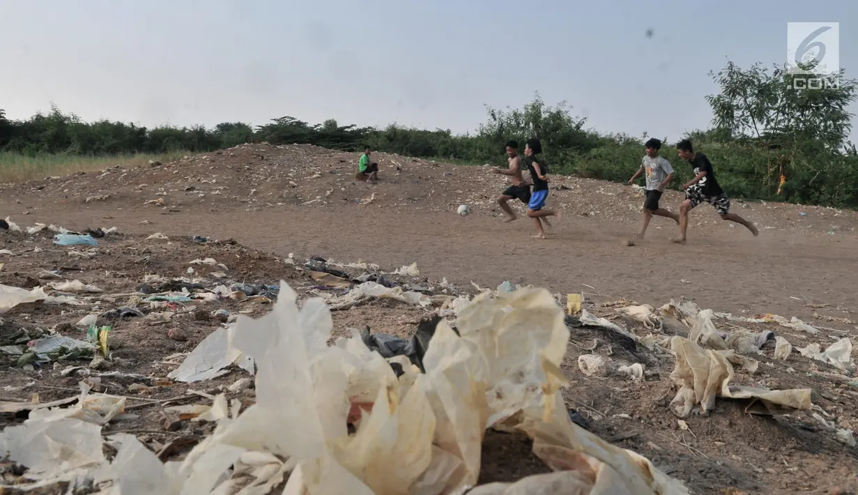 Anak-anak saat bermain sepakbola di tanah sengketa kawasan Pedongkelan, Jakarta, Kamis (11/7/2019). Meski bertempat tinggal di atas lahan sengketa, anak-anak setempat memanfaatkan tanah kosong yang penuh semak belukar tersebut sebagai sarana bermain ketika sore hari. (merdeka.com/Iqbal S. Nugroho)