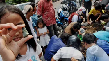 Seorang bocah memperlihatkan batu yang diduga jenis giok di Kawasan Tomang, Jakarta, Sabtu, (9/5/2015). (Liputan6.com/Andrian M Tunay)