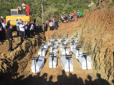 Pemakaman massal korban banjir bandang di Sentani, Kabupaten Jayapura, Papua, Rabu (27/3). Sebanyak 20 jenazah korban banjir bandang Sentani dimakamkan secara massal lantaran belum berhasil teridentifikasi.  (NETHY DHARMA SOMBA/AFP)