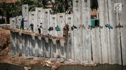 Sejumlah pekerja menyelesaikan pembangunan turap Kali Sunter Jakarta Utara, Selasa (18/12). Memasuki musim penghujan pembangunan turap terus dikebut. (Liputan6.com/Fery Pradolo)
