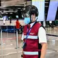 Petugas mengenakan termoscanner portabel "Smart-Helmet" untuk memeriksa suhu penumpang dan sesama staf di terminal keberangkatan bandara Fiumicino Roma, Italia pada 5 Mei 2020. Hal ini dilakukan guna menyaring orang yang memiliki gejala infeksi virus corona. (ANDREAS SOLARO/AFP)