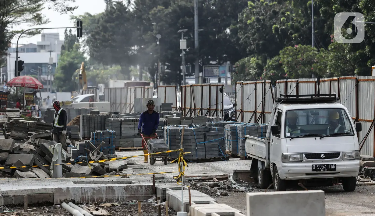 Pekerja mengerjakan proyek rivitalisasi jalan di kawasan Kota Tua, Jakarta Barat, Senin (17/5/2022). Revitalisasi difokuskan bagian Trotoar yang nantinya akan diperlebar menjadi tiga meter sehingga cukup luas untuk para pejalan kaki. Dan juga akan dilengkapi dengan ubin pengarah (guidingblock) serta jalur khusus sepeda. (Liputan6.com/Johan Tallo)
