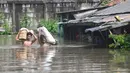 Warga menyelamatkan sagu miliknya saat banjir menggenangi kawasan Kampung Cantiga, Petir, Cipondoh, Kota Tangerang, Banten, Selasa (8/7/2025). (merdeka.com/Arie Basuki)
