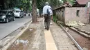 Pejalan kaki melintasi jalur pembangunan trotoar di Jalan Raya Ragunan, Jakarta, Rabu (12/10). Suku Dinas Bina Marga Jaksel mengalokasikan anggaran Rp 79 miliar untuk pembangunan dan perbaikan trotoar di 10 kecamatan Jaksel. (Liputan6.com/Yoppy Renato)