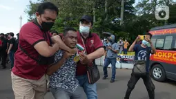 Aparat kepolisian mengamankan seorang pria saat unjuk rasa memperingati May Day atau Hari Buruh di kawasan Patung Kuda, Jakarta, Sabtu (1/5/2021). Polisi mengamankan sejumlah massa yang diduga mahasiswa dalam aksi unjuk rasa tersebut. (merdeka.com/Imam Buhori)