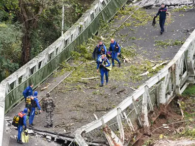 Tim penyelamat berjalan di atas jembatan gantung yang ambruk di atas sungai Tarm, Prancis, Selasa (18/11/2019). Jembatan gantung yang menghubungkan kota Mirepoix-sur-Tarn itu tiba-tiba ambruk hingga menyebabkan seorang gadis berusia 15 tahun dan satu sopir truk tewas. (ERIC CABANIS/AFP)