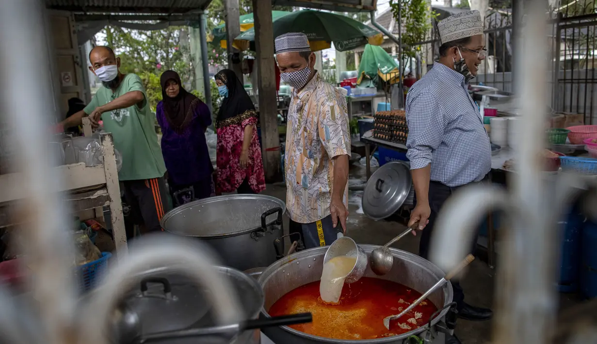 Sekretaris Masjid Bang Aw, Adul Yothasmutr (kanan) dan sukarelawan memasak kari ayam dan rebung di Bangkok, Thailand, Kamis (30/4/2020). Setiap hari selama Ramadan, sukarelawan membagikan makanan kepada 150 keluarga sekitar Masjid Bang Aw. (AP Photo/Gemunu Amarasinghe)