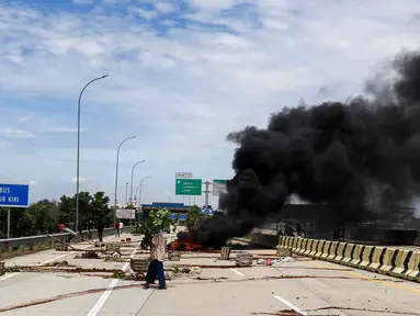 Sejumlah warga melakukan aksi menutup akses jalan menuju Gerbang Tol (GT) Jatikarya 1& 2, di Jalan tol Cimanggis-Cibitung, Bekasi, Jawa Barat, Rabu (8/2/2023). Dalam aksinya mereka menuntut Pengadilan Negeri Kota Bekasi segera menyelesaikan pembayaran atas penggunaan tanah untuk tol seluas 4,2 hektar. (Liputan6.com/Herman Zakharia)