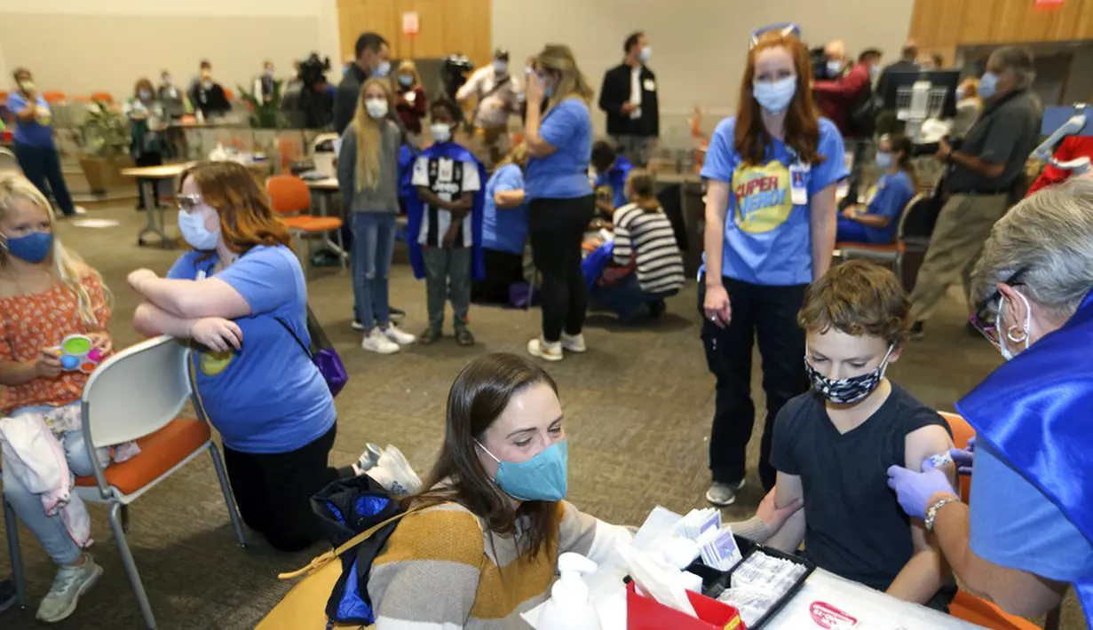 Pensiunan perawat Jill Rill (kanan) membalut Jackson Stukus, 11, usai dia menerima vaksin COVID-19 Pfizer di Franklin County, Rumah Sakit Anak Nasional, Columbus, Ohio, Amerika Serikat, 3 November 2021. AS gelar vaksinasi COVID-19 untuk anak-anak berusia 5-11 tahun. (AP Photo/Paul Vernon)