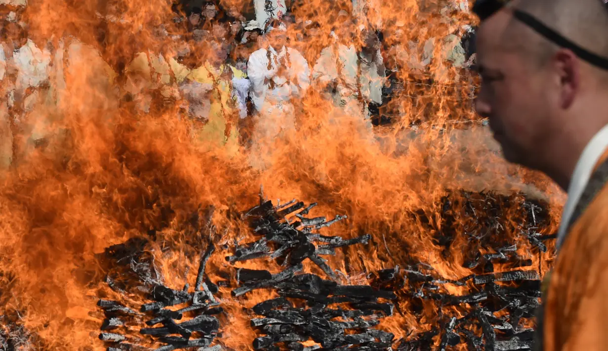 Biksu Buddha berdoa di depan kobaran api saat festival berjalan di atas api atau dikenal sebagai “Nagatoro Hi-Matsuri,” di kuil Fudoji, kota Nagatoro, Jepang, Minggu (5/3). Festival ini diadakan untuk menyambut datangnya musim semi. (Kazuhiro NOGI/AFP)