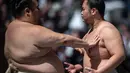 <p>Para pegulat sumo melakukan pemanasan sebelum "turnamen sumo besar nazar", sebuah pameran sumo seremonial, di halaman Kuil Yasukuni di Tokyo pada 17 April 2023. (AFP/Philip Fong)</p>