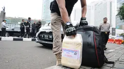 Petugas mengamankan cairan kimia yang diduga bahan narkoba dari dalam kendaraan yang dibawa WNA usai melawan arus dan menabrak petugas Polisi Militer (PM) yang sedang bertugas di kawasan Dukuh Atas, saat di amankan di pospol Bundaran HI, Jakarta, Rabu (15/5/2019). (Liputan6.com/Herman Zakharia)