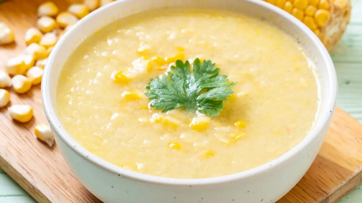 Bubur Jagung Tradisional: Seporsi bubur jagung hangat dengan santan kental dan aroma daun pandan