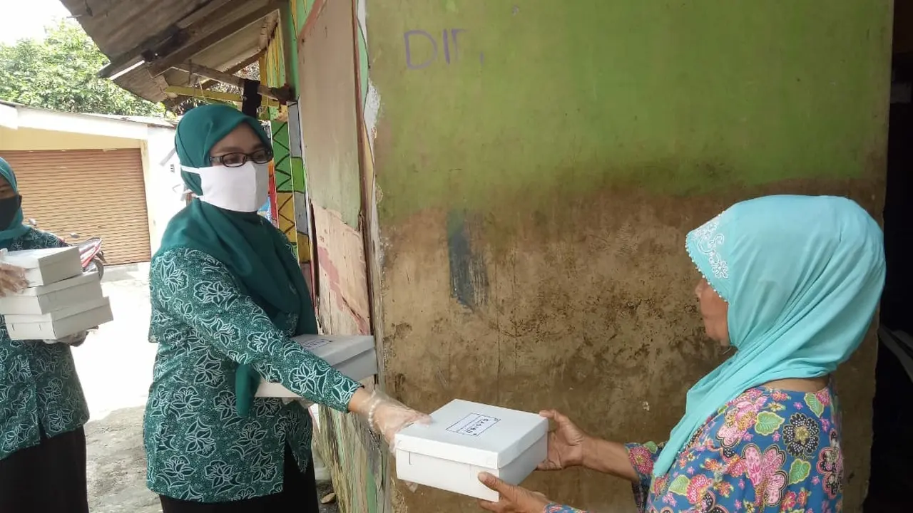 Ibu-ibu membagikan nasi bungkus.