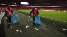 Petugas mengumpulkan pesawat terbang kertas yang dilemparkan suporter selama pertandingan Inggris melawan Slovenia di kualifikasi Piala Dunia 2018 di stadion Wembley, London, (5/10). AFP Photo/Adrian Dennis)