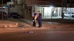 Pasukan keamanan Irak mengeledah seorang bocah  yang membawa bom di Kirkuk, Irak, (21/8). Bocah ini menangis saat diamankan oleh petugas keamanan. (REUTERS/Ako Rasheed)
