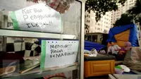 Tulisan penolakan masih terlihat diantara perabot rumah tangga di sisi Jalan Rawajati Barat, Jakarta, Jumat (2/9). Pasca penggusuran pemukiman bantaran rel kereta kawasan Rawajati, sejumlah warga masih memilih bertahan. (Liputan6.com/Helmi Fithriansyah)