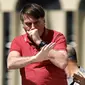 Presiden Brasil Jair Bolsonaro batuk saat berbicara dalam protes karantina dan jarak sosial untuk memerangi wabah virus corona COVID-19 di Brasilia, Brasil, 19 April 2020. Bolsonaro sempat dinyatakan negatif COVID-19 setelah beberapa ajudannya positif kena virus. (Sergio LIMA/AFP)