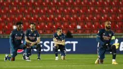 Sebelum kick-off berlangsung, Alexandre Lacazette yang ditunjuk sebagai kapten memimpin rekan-rekannya untuk berlutut di depan dengan para pemain Slavia Praha. (AP Photo/Petr David Josek)