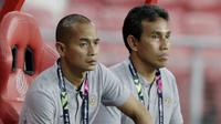 Pelatih Timnas Indonesia, Bima Sakti dan Kurniawan Dwi Yulianto, mengamati permainan saat melawan Singapura pada laga Piala AFF 2018 di Stadion Nasional, Singapura, Jumat (9/11). Singapura menang 1-0 atas Indonesia. (Bola.com/M. Iqbal Ichsan)