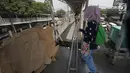 Pejalan kaki melewati lubang di atas JPO di Halte Bus Transjakarta di Jembatan Gantung, Cengkareng, Jakarta, Jumat (27/7). JPO yang rusak akibat tertabrak truk sejak setahun lalu hingga kini belum diperbaiki.  (Liputan6.com/Arya Manggala)