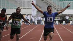 Atlet Sumatra Barat, Yaspi Boby (kanan), meraih emas lari 100m putra PON XIX Jawa Barat 2016 mengalahkan atlet NTB, Iswandi (tengah), dalam final di Stadion Pakansari, Bogor, Kamis (22/9/2016). (Bola.com/Arief Bagus)