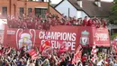 Para pemain Liverpool menyapa fans saat parade juara Liga Champions 2019 di Liverpool, Minggu (2/6). Ribuan fans tumpah ruah di jalanan untuk merayakan keberhasilan pemain membawa pulang trofi Si Kuping Besar ke kota Liverpool. (AP/Barrington Coombs)