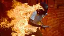 Seorang demonstran berlari saat tubuhnya terbakar disela unjuk rasa yang diwarnai bentrokan menentang Presiden Venezuela, Nicolas Maduro di Caracas, Rabu (3/5). Pria itu tersulut api dari ledakan tangki sepeda motor milik polisi. (RONALDO SCHEMIDT / AFP)