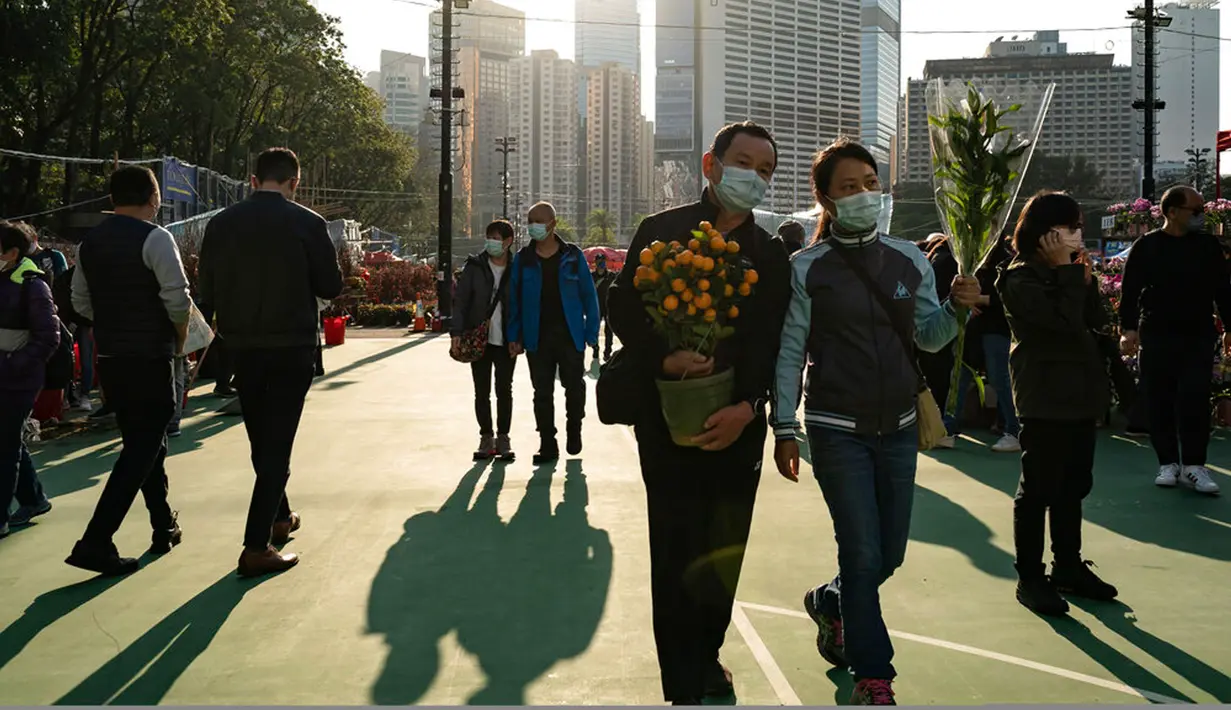 Para pembeli memegang karangan bunga dan tanaman jeruk keprok atau jeruk mandarin di pasar bunga Tahun Baru Imlek di Distrik Causeway Bay, Hong Kong, 18 Januari 2023. Tahun Baru Imlek 2023 yang disebut Tahun Kelinci akan jatuh pada tanggal 22 Januari. (AP Photo/Anthony Kwan)