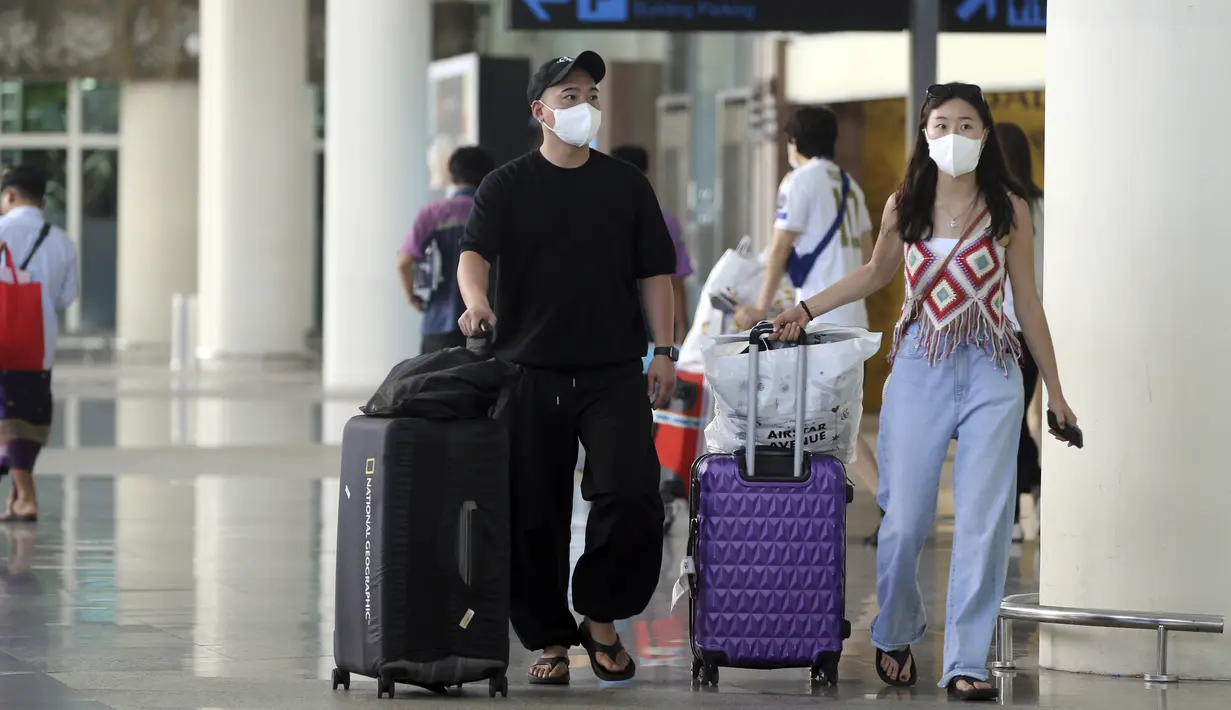 <p>Wisatawan mancanegara (wisman) asal China membawa barang bawaan mereka saat tiba di bandara internasional Ngurah Rai di Bali, Minggu (22/1/2023). Kedatangan kembali turis Chiba ini diharapkan dapat mendukung target kunjungan wisatawan mancanegara yang tahun ini mencapai 3,5 juta hingga 7,4 juta kunjungan. (AP Photo/Firdia Lisnawati)</p>