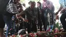 Penaburan bunga di atas makam Pelawak Senior Cahyono di TPU Komplek TVRI, Jakarta, Kamis (25/5). Cahyono meninggal karena menderita komplikasi serangan jantung dan diabetes. (Liputan6.com/Herman Zakharia)