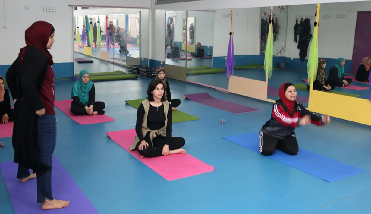 Wanita Palestina mengikuti sesi latihan yoga di pusat pelatihan yoga wanita pertama di kota Gaza, 28 Maret 2018. Mereka belajar yoga untuk membantu warga lain menghadapi stres dan trauma karena tinggal di kawasan dalam sengketa. (MOHAMMED ABED/AFP)